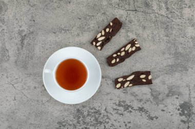 Cup of black tea with cocoa crackers on stone table. High quality photo