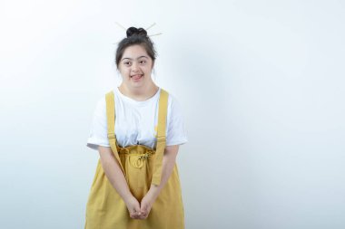 Beyaz duvarın karşısında duran ve gülümseyen genç, güzel kız modeli. Yüksek kalite fotoğraf