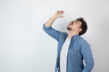 Çekici bir adamın cam bir kavanozdan ayakta durup içerkenki fotoğrafı. Yüksek kalite fotoğraf