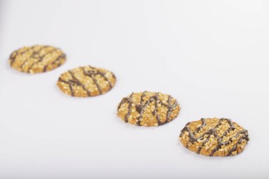 Fındıklı lezzetli yulaf kurabiyeleri ve beyaz yüzeyde çikolata. Yüksek kalite fotoğraf