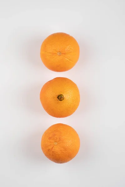 Tres Naranjas Frescas Enteras Colocadas Sobre Una Mesa Blanca Foto —  Fotos de Stock