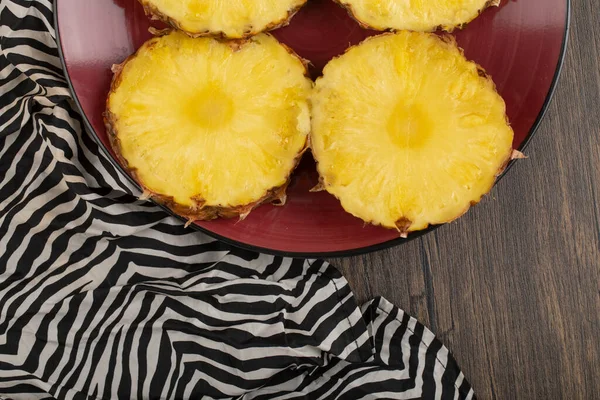 Verse Rijpe Ananasschijfjes Een Rode Plaat Een Houten Tafel Hoge — Stockfoto