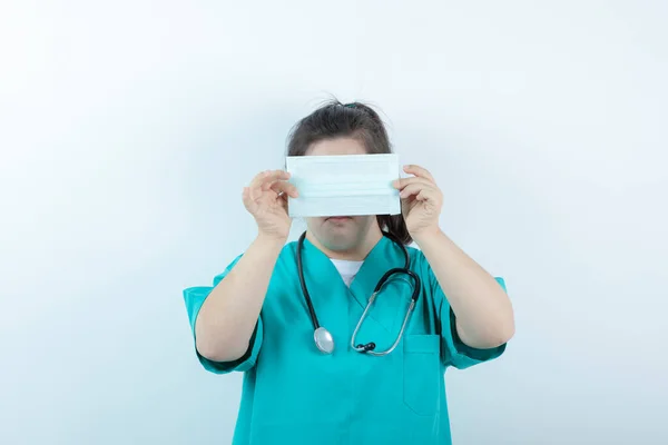 Jonge Vrouwelijke Verpleegster Met Stethoscoop Met Medisch Gezichtsmasker Tegen Witte — Stockfoto