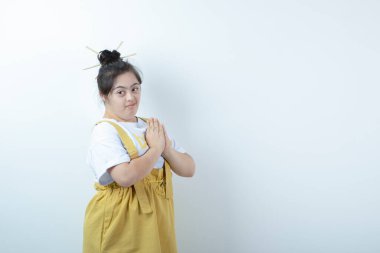 Beyaz duvara karşı duran ve poz veren genç, güzel bir kız. Yüksek kalite fotoğraf