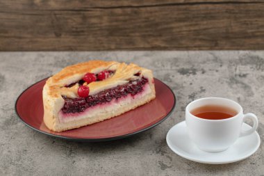Lezzetli böğürtlenli dilimlenmiş cheesecake ve beyaz bir fincan çay. Yüksek kalite fotoğraf