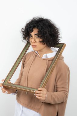 Beyaz arka planda resim çerçeveli genç bir kadının portresi 