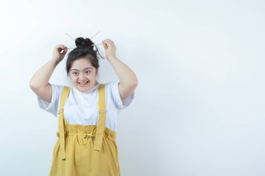 Beyaz duvara karşı duran ve poz veren genç, güzel bir kız. Yüksek kalite fotoğraf