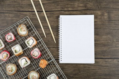 Ahşap zemin üzerinde çubuklar olan çeşitli suşi ruloları. Yüksek kalite fotoğraf