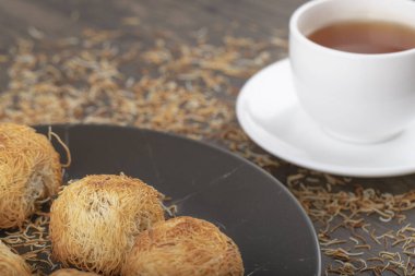 Tahta masaya beyaz bir fincan sıcak çay konmuş Türk tatlıları. Yüksek kalite fotoğraf