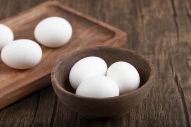 Tabaktaki taze yumurtaların ve ahşap tepsinin fotoğrafını çek. Yüksek kalite fotoğraf