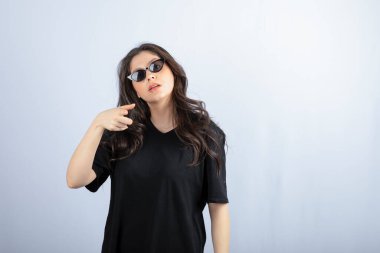 Güneş gözlüklü ve kameraya doğrultulmuş şık bir genç kadın pozu. Yüksek kalite fotoğraf