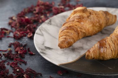 Güzel bir tabağa yerleştirilmiş lezzetli tereyağlı kruvasanlar. Yüksek kalite fotoğraf