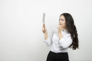 Beyaz duvara bıçak dayamış genç bir kadın. Yüksek kalite fotoğraf