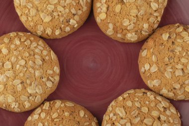 Kırmızı tabağa yerleştirilmiş tohumlu ve tahıllı yulaflı kurabiyeler. Yüksek kalite fotoğraf