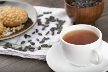 Tahta bir masaya yerleştirilmiş beyaz fincanlı çok tahıllı kurabiyeler. Yüksek kalite fotoğraf