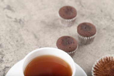 Mini chocolate brownies and cup of black tea on stone. High quality photo