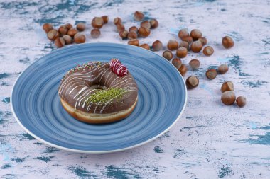 Çikolatalı çörek ve beyaz yüzeyde kabuklu fındık. Yüksek kalite fotoğraf