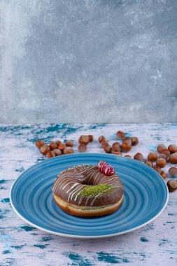 Çikolatalı çörek ve beyaz yüzeyde kabuklu fındık. Yüksek kalite fotoğraf