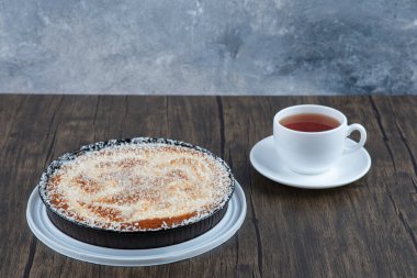 Tahta masaya bir fincan siyah çay ile bir tabak lezzetli turta. Yüksek kalite fotoğraf