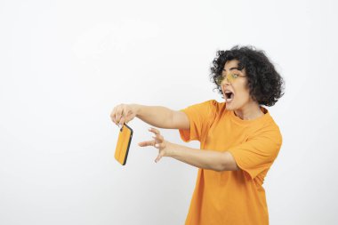 Akıllı telefonlu genç kadın beyaz arka planda poz veriyor 