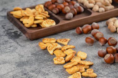 Tahtada fındıklı çıtır krakerler ve kabuklu fıstıklar. Yüksek kalite fotoğraf