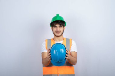 Beyaz arka planda şapkası olan genç bir inşaat işçisi. Yüksek kalite fotoğraf