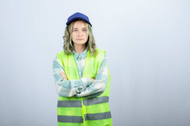 Üniformalı genç bayan mimar beyaz duvarın üzerinde kollarını kavuşturdu. Yüksek kalite fotoğraf