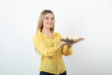 Beyaz turp sebzelerinden ahşap bir tahta tutan güzel bir genç kadının fotoğrafı. Yüksek kalite fotoğraf