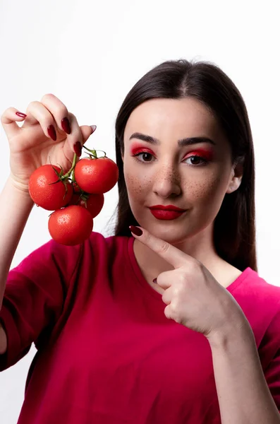 Mooi Meisje Die Wijst Naar Een Bos Rode Tomaten Tegen — Stockfoto