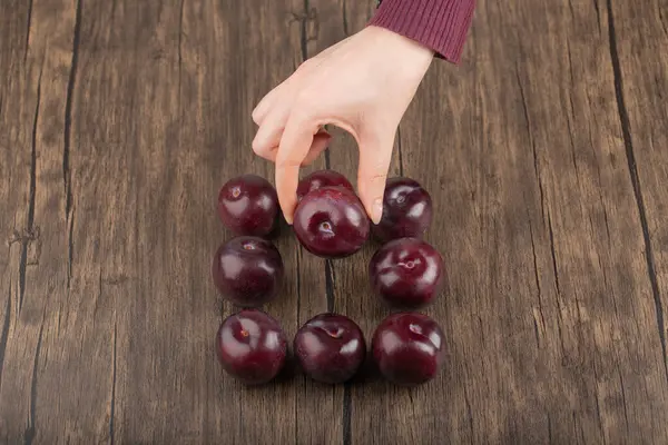 Mano Femenina Sosteniendo Ciruela Fresca Sobre Una Superficie Madera Foto — Foto de Stock