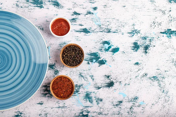Biber taneleri, toz ve mavi tabakla taş masaya konur. Yüksek kalite fotoğraf