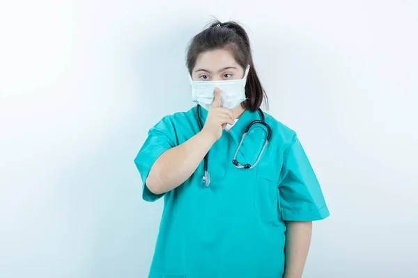 Jonge Vrouwelijke Verpleegster Met Stethoscoop Medisch Gezichtsmasker Doet Stil Teken — Stockfoto