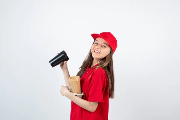 Imagem Uma Jovem Adolescente Uniforme Vermelho Segurando Duas Xícaras Café — Fotografia de Stock