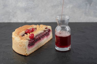 Dilimlenmiş lezzetli peynirli kek, böğürtlenli ve bir bardak taze meyve suyu, siyah arka planda. Yüksek kalite fotoğraf