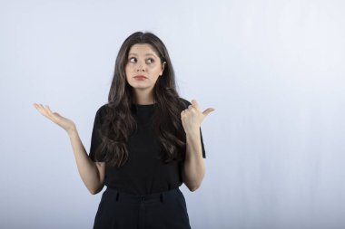 Beyaz arka planda duran siyahlı genç kadın portresi. Yüksek kalite fotoğraf