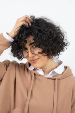 Beyaz arka planda poz veren genç bir kadın 