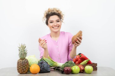 Masasında oturan pembe bluzlu, kıllı hindistan cevizli genç kıvırcık kadın. Yüksek kalite fotoğraf