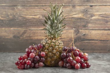 Olgun ananaslı taze kırmızı üzümler mermer yüzeyde. Yüksek kalite fotoğraf