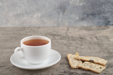 Bir fincan siyah çay ve taştan bir masaya yerleştirilmiş fındıklı dilimlenmiş ekmek. Yüksek kalite fotoğraf