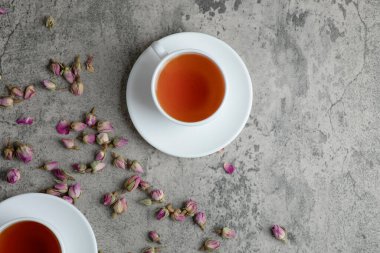 Mermer zemin üzerinde kurumuş çiçekler olan iki fincan siyah çay. Yüksek kalite fotoğraf