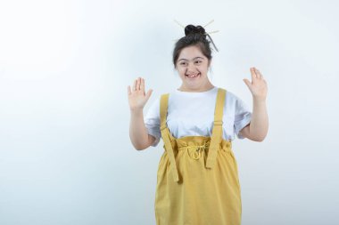 Beyaz duvara karşı duran ve poz veren genç, güzel bir kız. Yüksek kalite fotoğraf