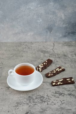 Cup of black tea with cocoa crackers on stone table. High quality photo