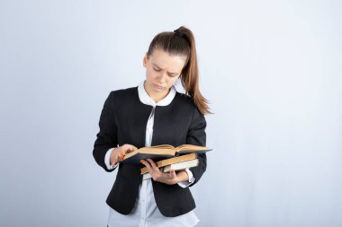 Beyaz arka plan üzerine ilginç kitaplar okuyan genç bir kızın portresi. Yüksek kalite fotoğraf