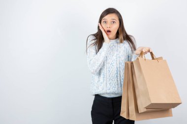 Süveter giymiş genç bir kızın elinde kese kâğıdıyla fotoğrafı. Yüksek kalite fotoğraf