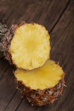 Tahta arka planda tacı olan iki parça ananas. Yüksek kalite fotoğraf