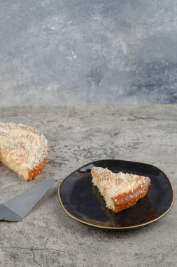 Taş zeminde siyah bir tabak lezzetli vanilyalı kek. Yüksek kalite fotoğraf