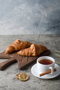 Taze ve lezzetli kruvasanlar ve bir fincan sıcak çay. Yüksek kalite fotoğraf