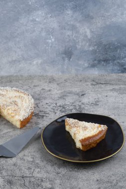 Mermer zemin üzerinde lezzetli bir parça kek olan siyah bir tabak. Yüksek kalite fotoğraf