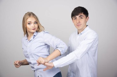 Gri arka planda birlikte duran genç bir çiftin portresi. Yüksek kalite fotoğraf