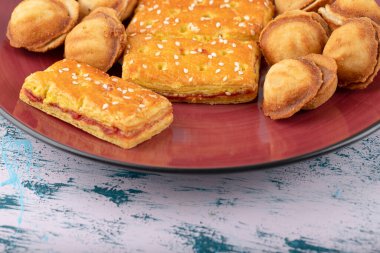 Erkek el, tabağa yerleştirilmiş ceviz şeklinde küçük kurabiyelerin yanında tatlı kraker yiyor. Yüksek kalite fotoğraf